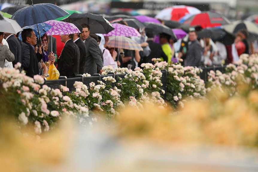 Race-goers keep the rain away at Flemington