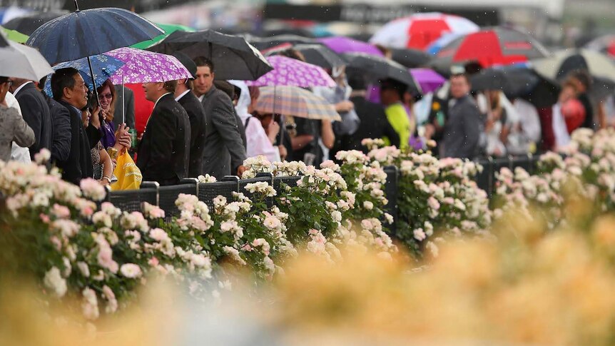 Race-goers keep the rain away at Flemington