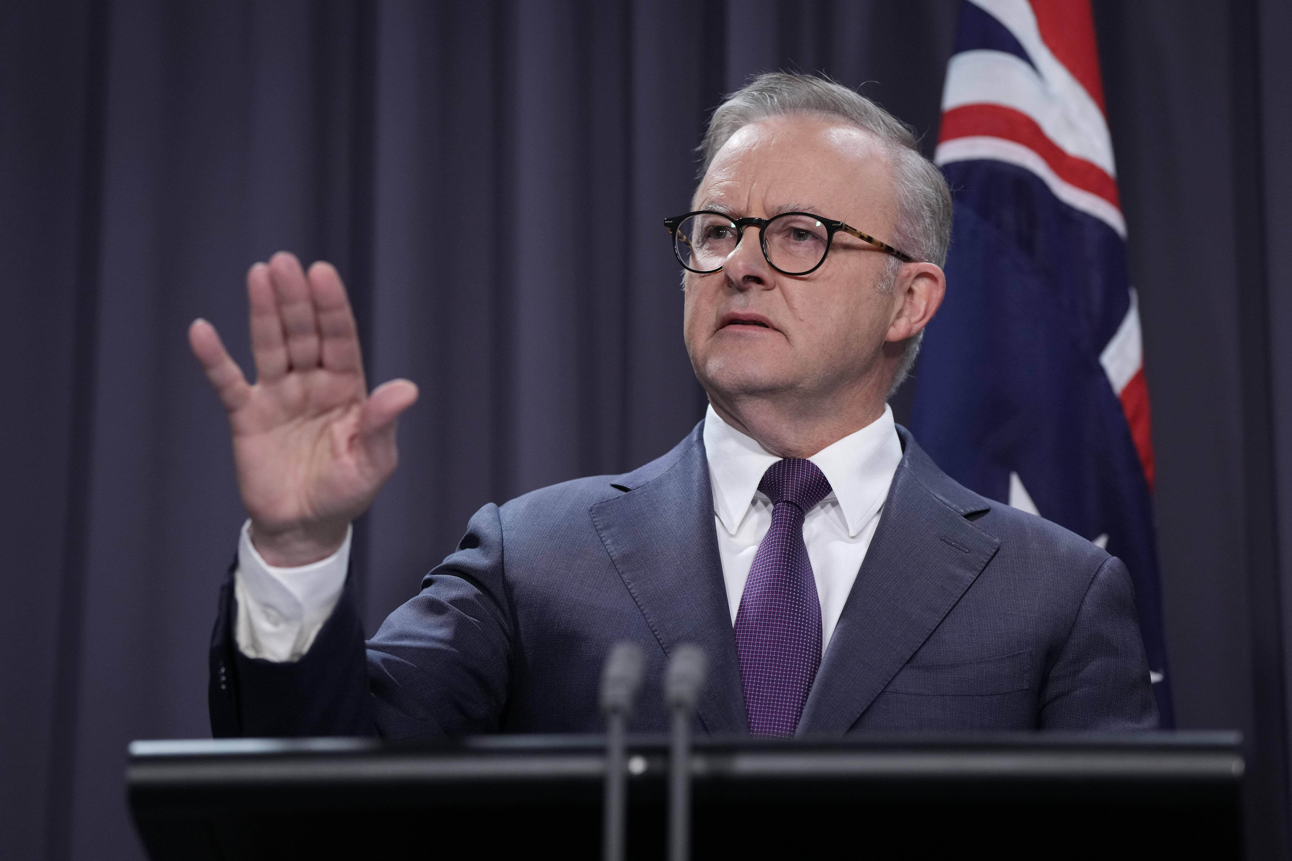 Anthony Albanese holds up his hand to take a question at ta press conference