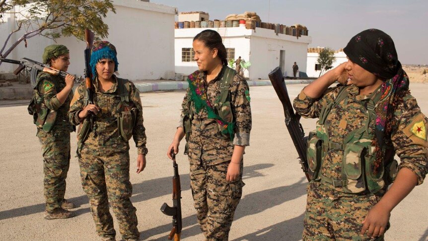 17-year old Amara from Raqqa, 2nd L, talks with other YPJ trainees before the military drill.