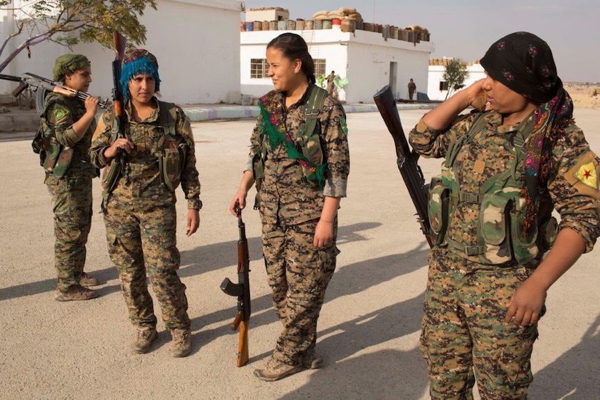 17-year old Amara from Raqqa, 2nd L, talks with other YPJ trainees before the military drill.