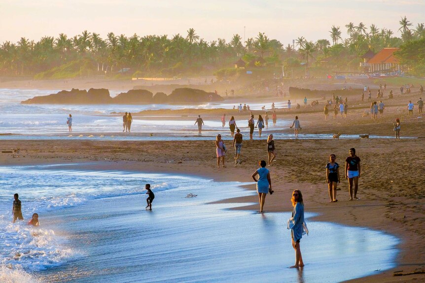 People at a Bali beach as the sun sets