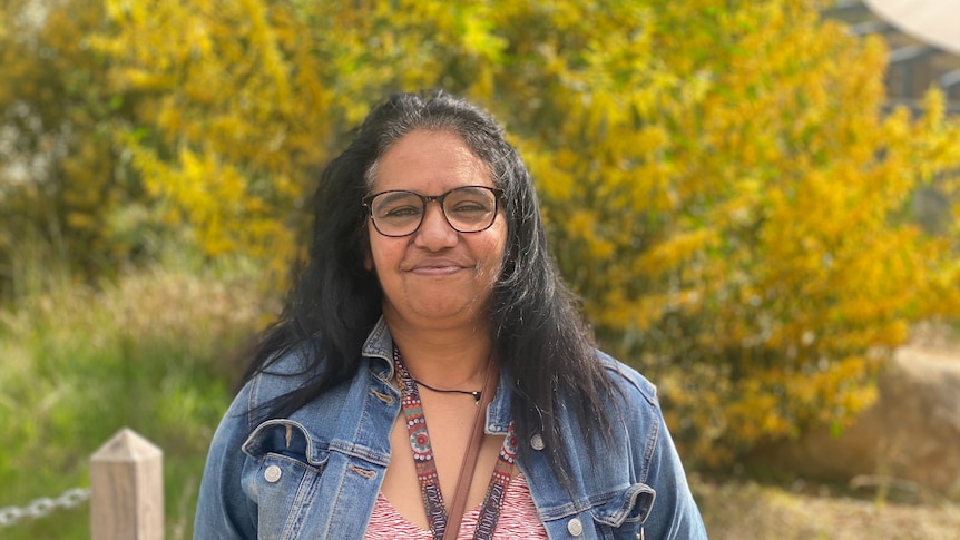 A smiling Indigenous woman with long dark hair.