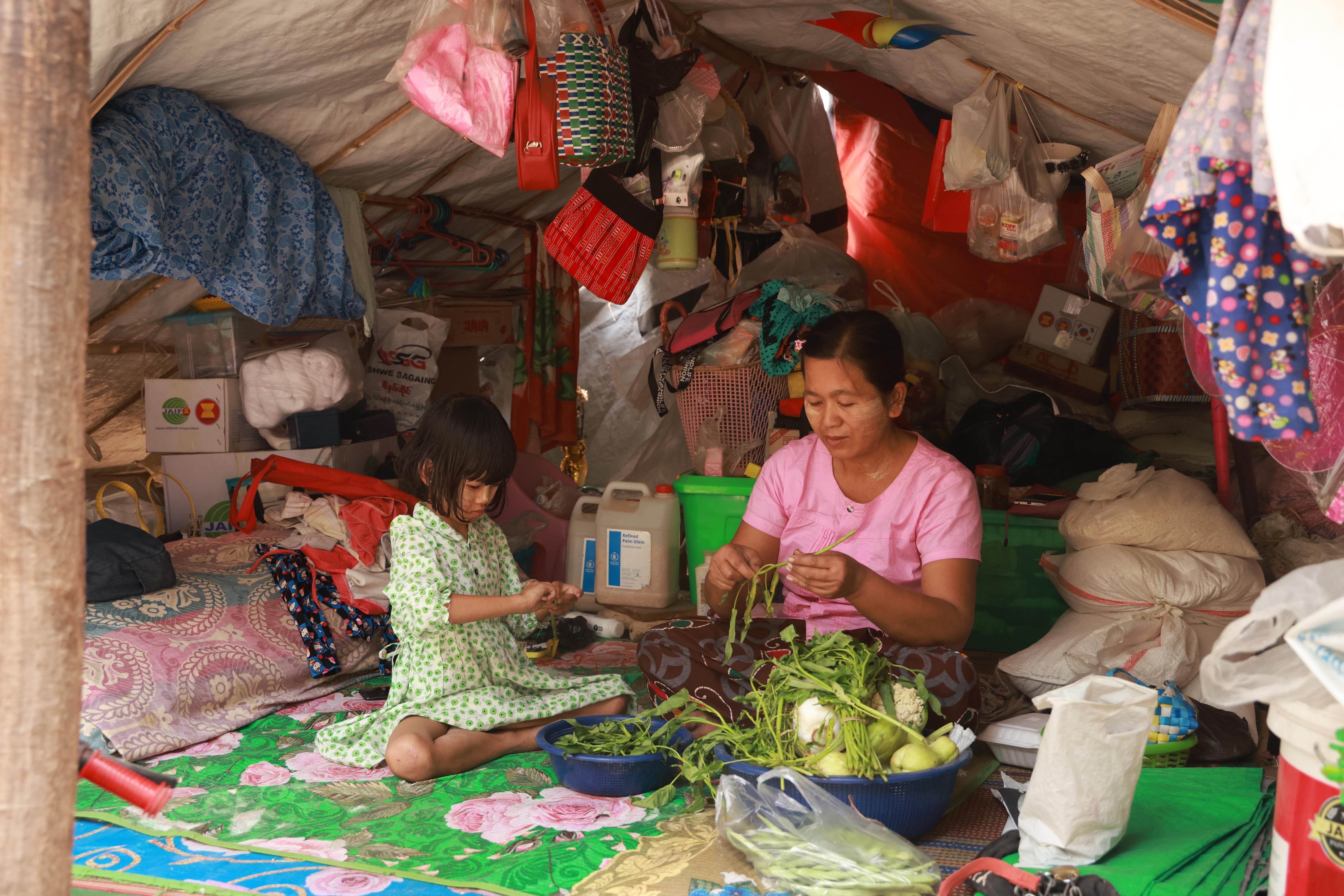 Mother and child shelters at a monastery, sitting around baskets.