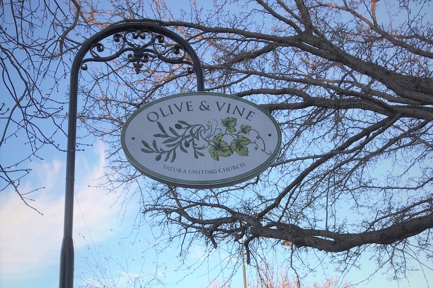 A sign in front of a tree