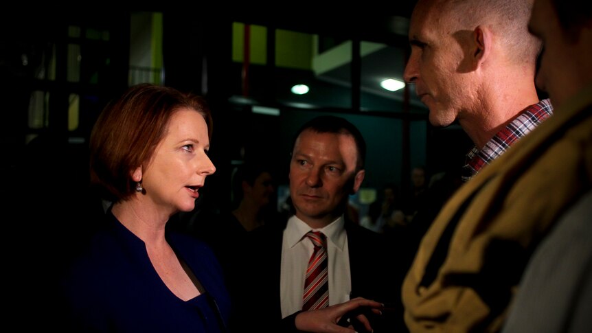Julia Gillard, flanked by local MP Graham Perrett, meets a member of the public before community cabinet in Brisbane.