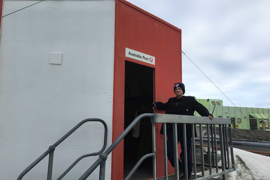 A post office worker standing at the entrance of Davis Post Office.