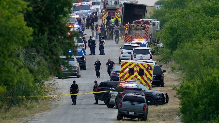 Police work the scene where dozens of people were found dead