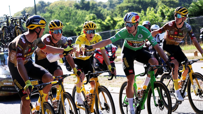 Five team members, including the yellow and green jersey leaders, have a glass of wine on final stage of the Tour de France.