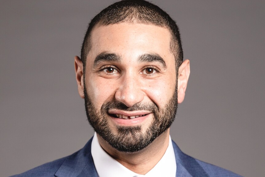 A photo of Alaa Elzokm wearing a blue suit, smiling.