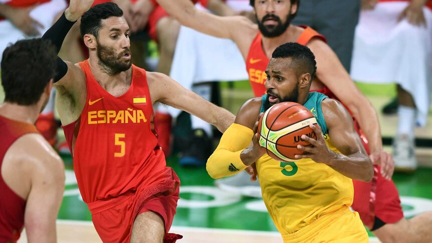 The Boomers' Patty Mills drives past Spain's Sergio Llull at the Olympics