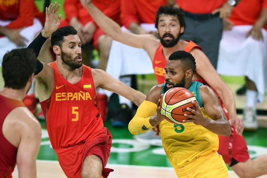 The Boomers' Patty Mills drives past Spain's Sergio Llull at the Olympics