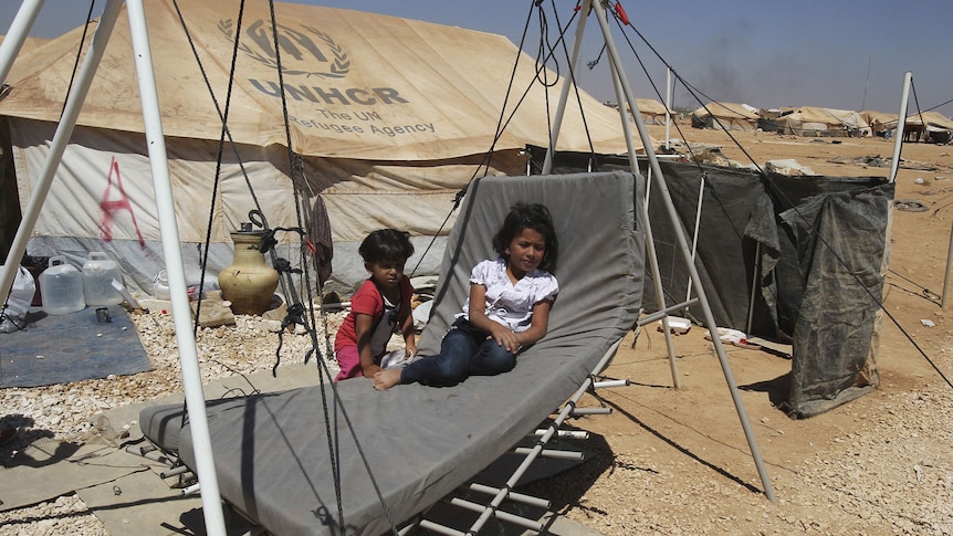 Syrian children play outside their tent at the camp, which is near the border with their country.