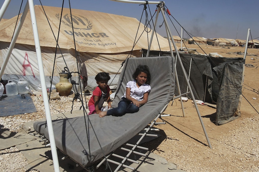Syrian children play outside their tent at the camp, which is near the border with their country.