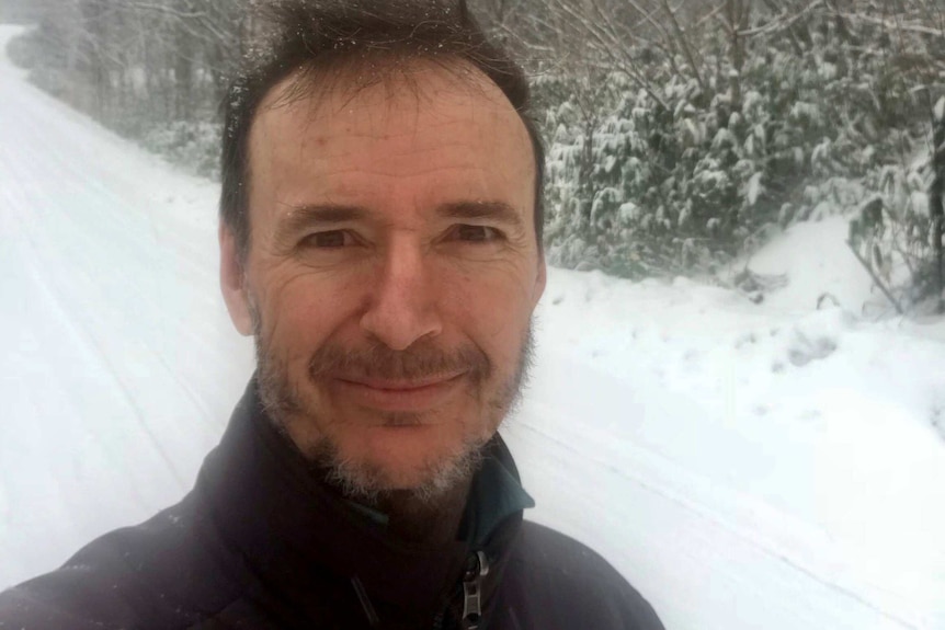 Former Redland councillor Craig Ogilvie stands on a snow-covered road.