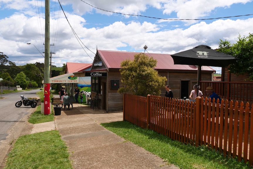 A country street with a small cafe and table and chairs.