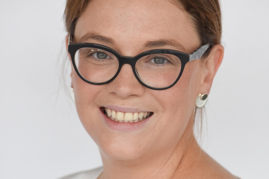 woman wearing glasses with a white backdrop