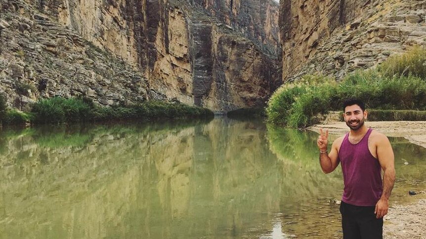 Matt Palazzolo poses for a photo in a gorge beside a river.