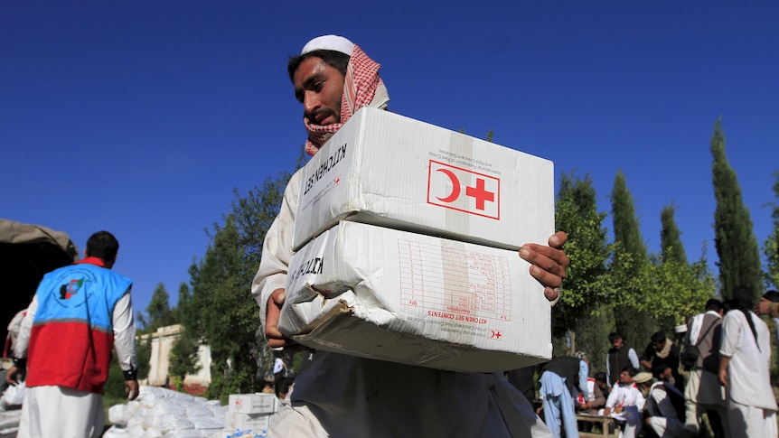 An Afghan man receives aid from the Red Cross