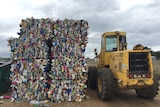 Bales of plastic waste next to a bobcat vehicle