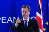 British PM David Cameron speaks in front of UK and EU flags