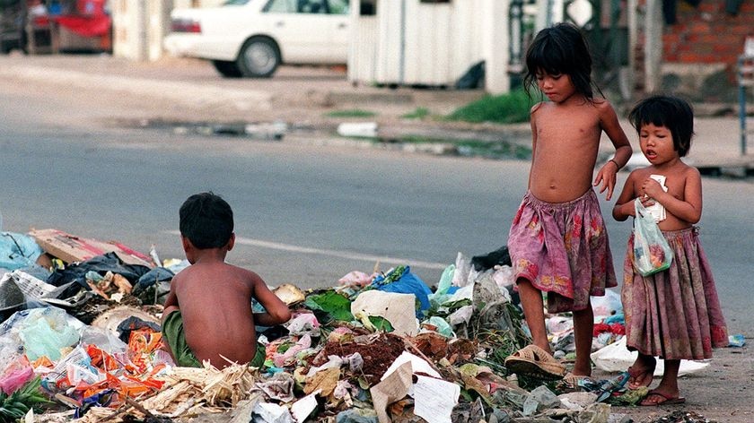 Cambodian children sort through a pile of garbage.