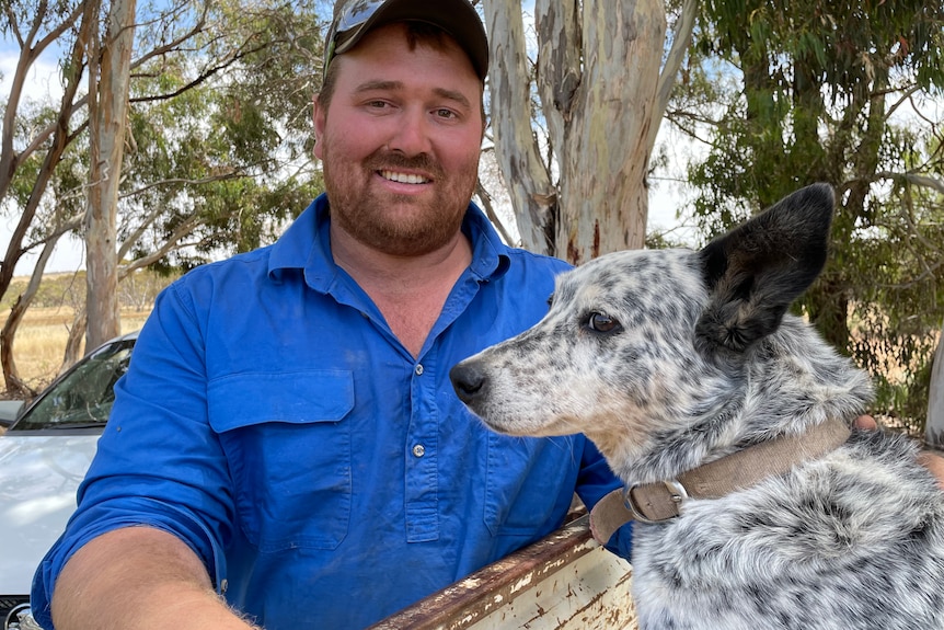 Photo of a man smiling with a dog.