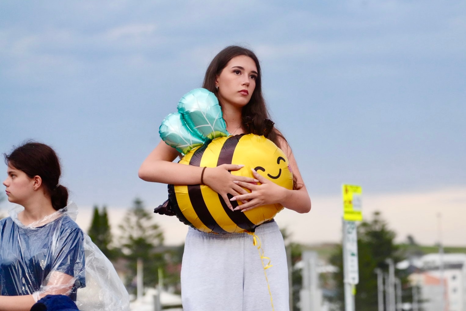 Jovem segura um balão de abelha na vigília oficial de Bondi Beach