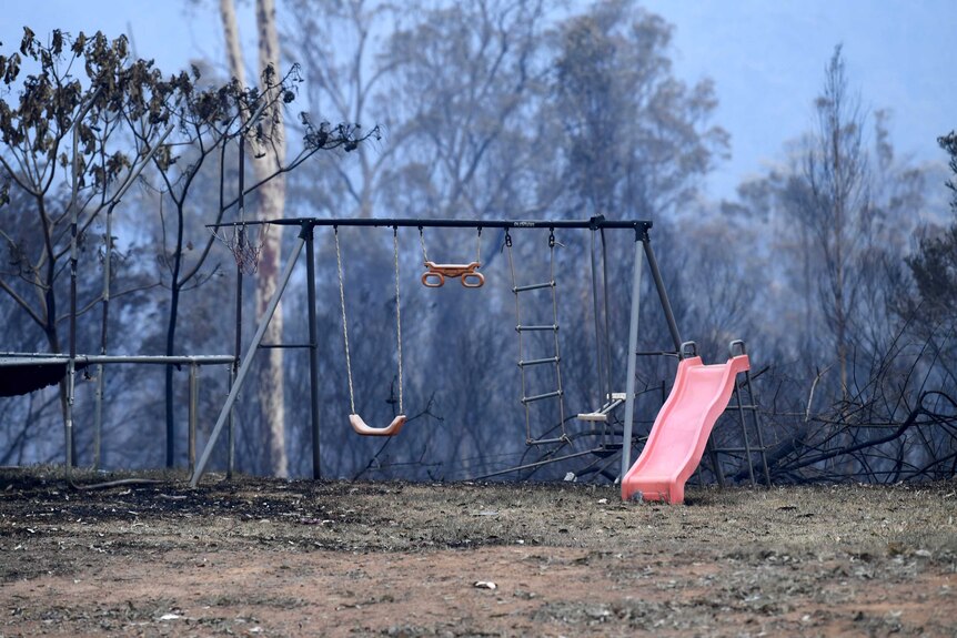 Children's play equipment stands in a burnt out yard on Bullocky Way, Possum Brush.
