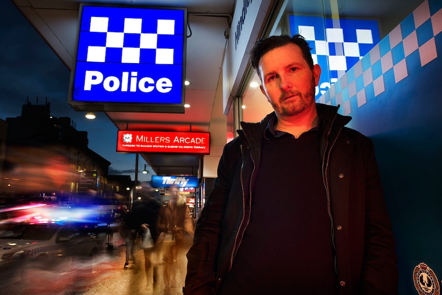 A man standing outside a police station