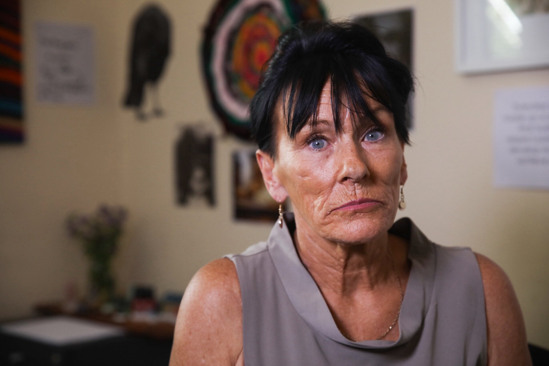 A woman with black hair looks into the camera.