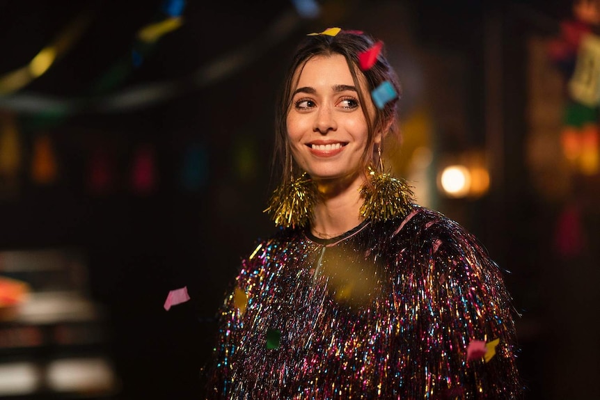 Cristin Milioti in sparkly dress and sparkly earrings at a wedding in the film Palm Springs