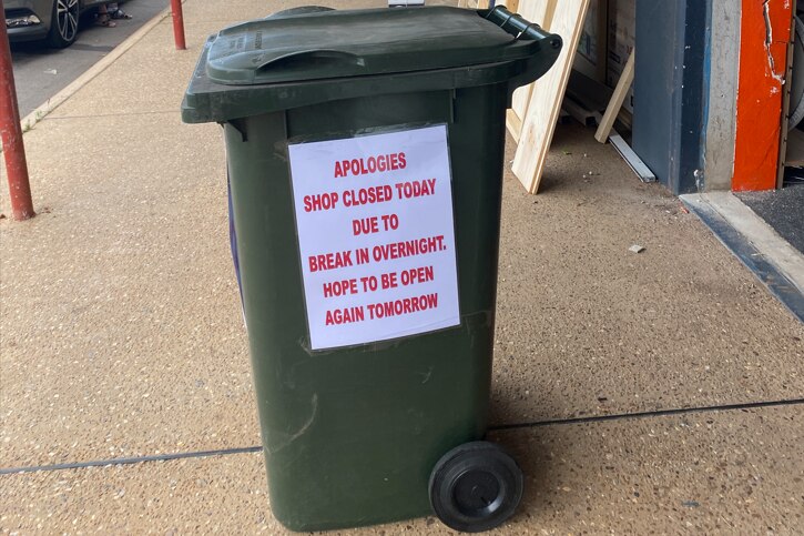 A close-up of a bin with a sign reading "apologies shop closed today due to break in overnight. Hope to be open again tomorrow."