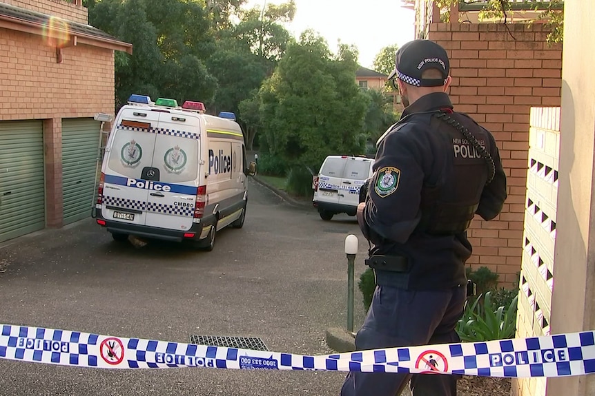 nsw police stand next to police tape at the scene of a stabbing murder in oatlands in august 2020