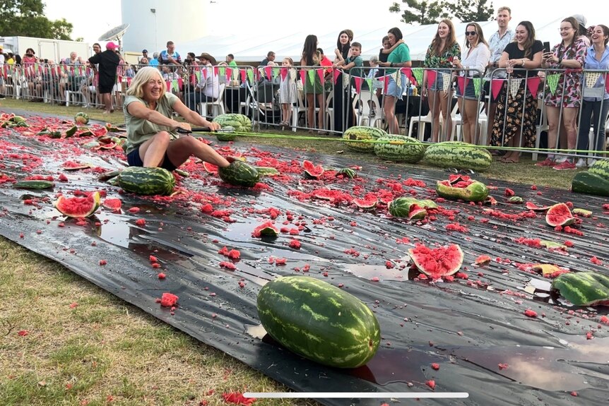 A woman skis along a tarp with her feet in some watermelons