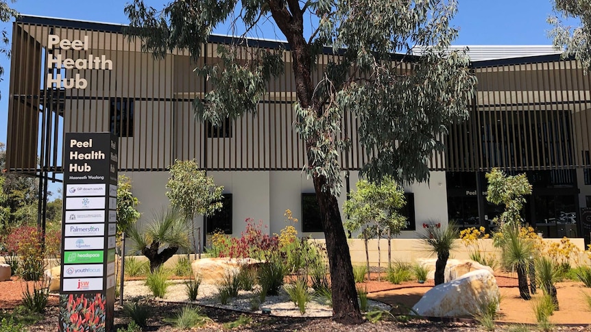 The Peel Health Hub building with trees and shrubs in the foreground.