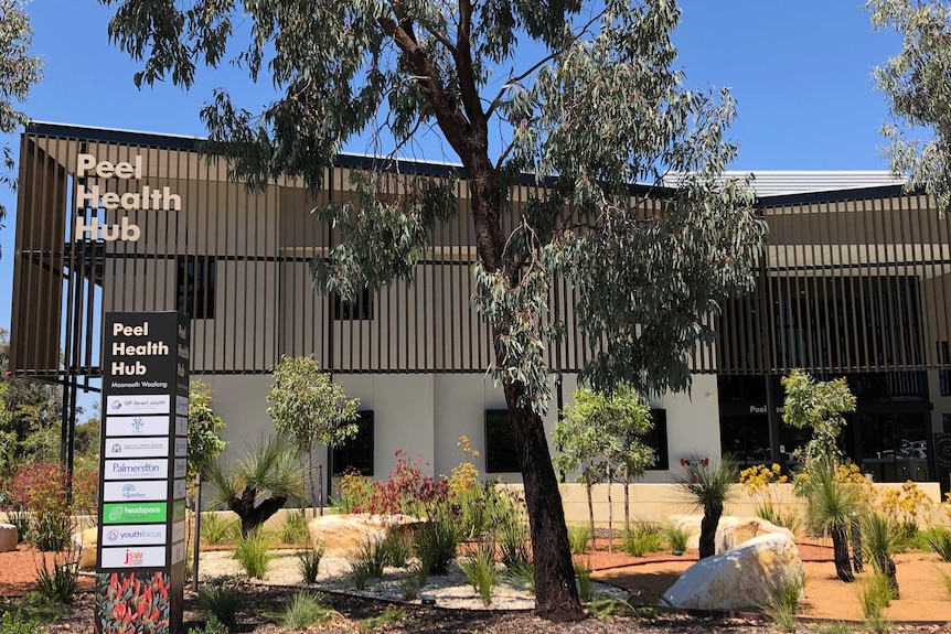 The Peel Health Hub building with trees and shrubs in the foreground.