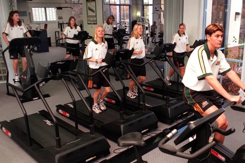 Women athletes running on treadmills and using a stationary bike at a gym