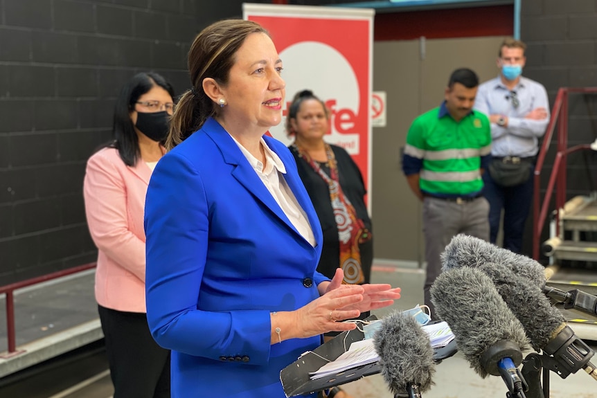 Palaszczuk speaking in front of some microphones.