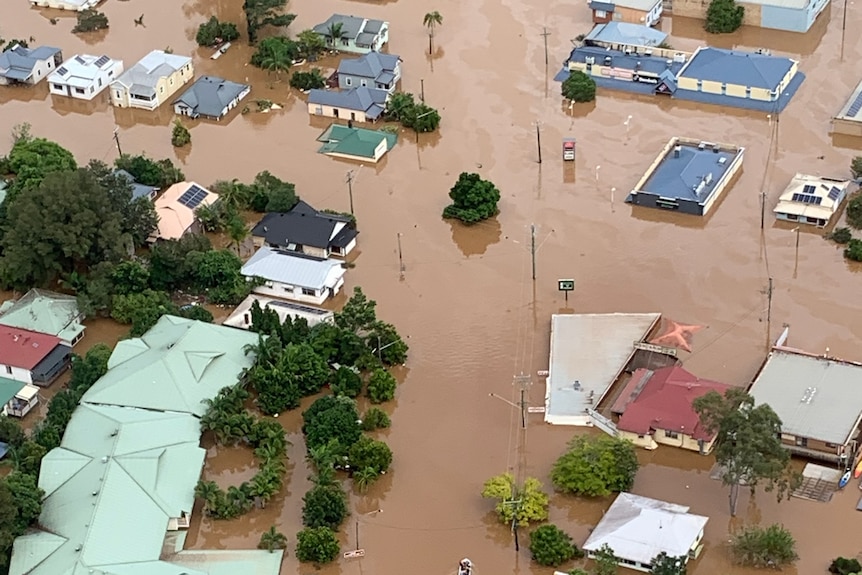 Aerial view of several homes submerged in brown flood waters