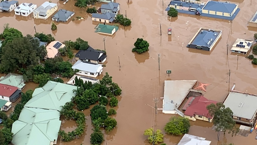 Aerial view of several homes sumberged in brown flood waters