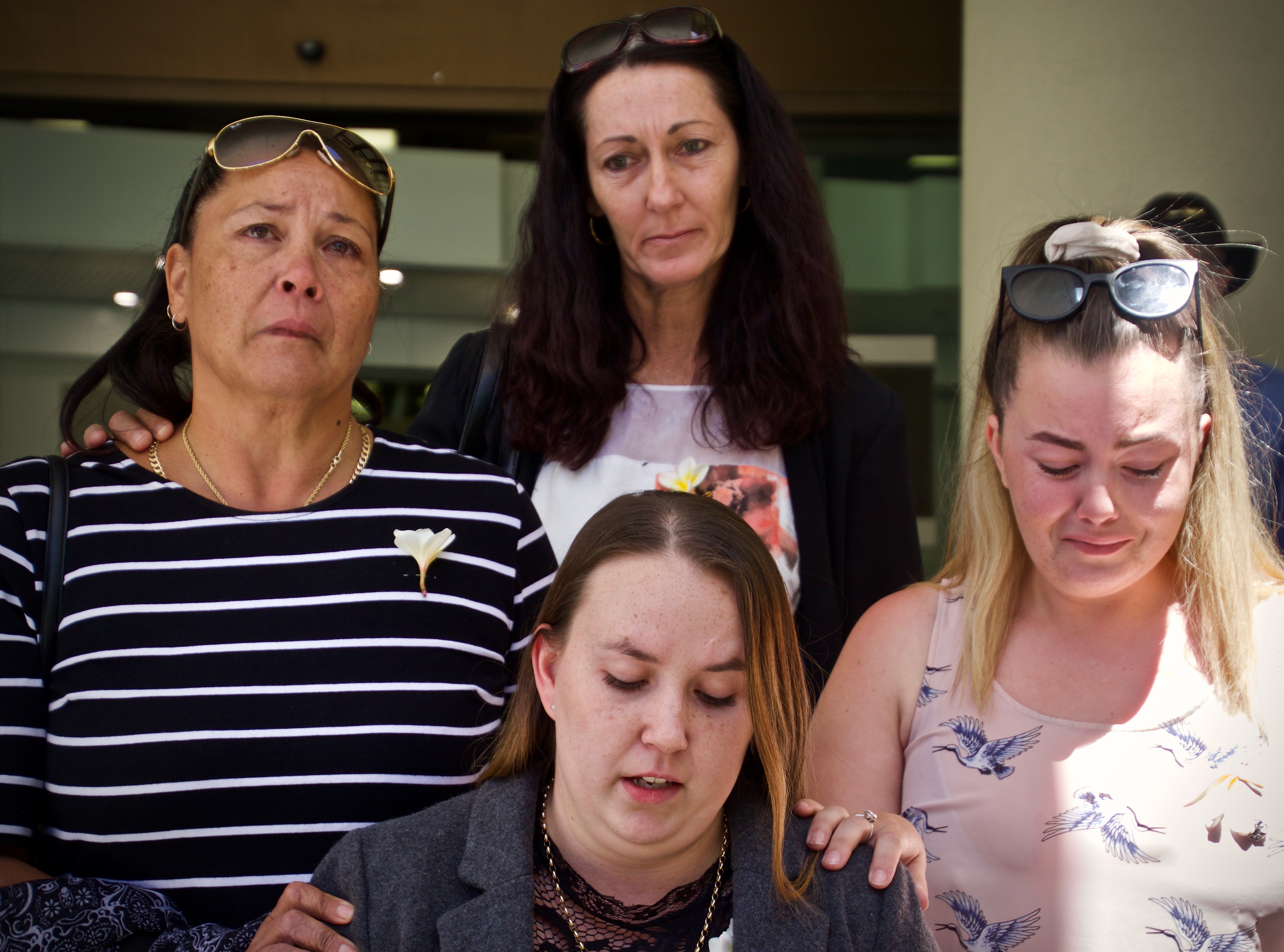 A group of four women look grief-stricken standing outside an inquest