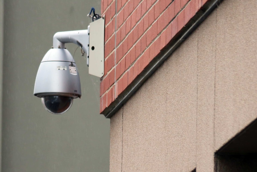A security camera mounted to the side of a building in hobart.