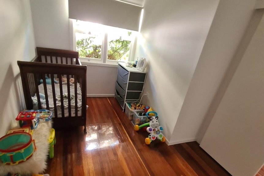 A cot and plastic tubs with toys in them.