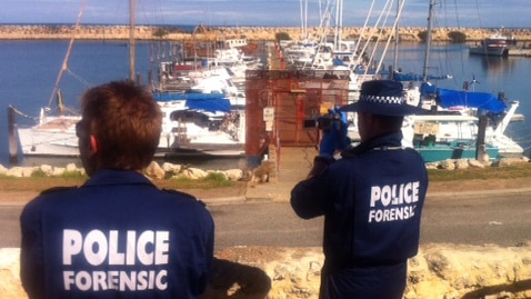 Two forensic officers take video at marina