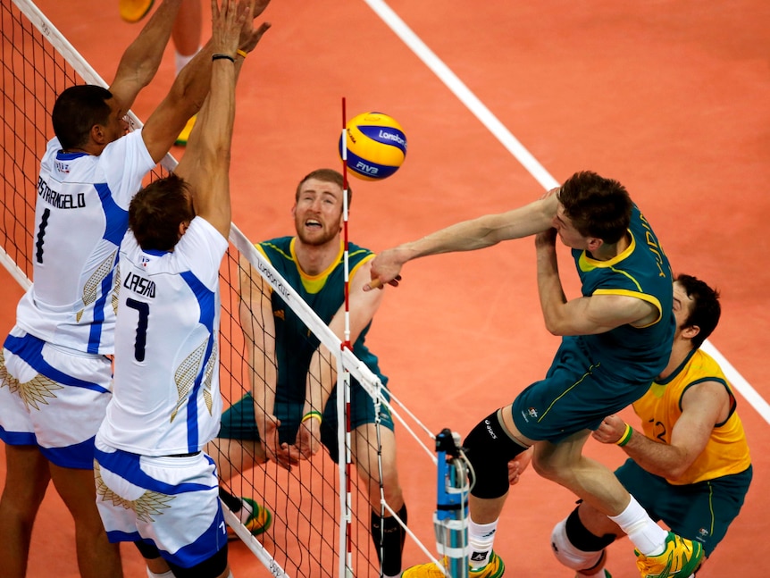 Thomas Edgar (R) spikes against Italy during their Group A volleyball match at the London Olympics.