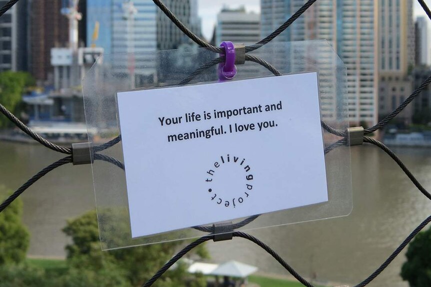 Laminated sign 'Your life is important and meaningful. I love you' zip-tied on a Brisbane bridge.