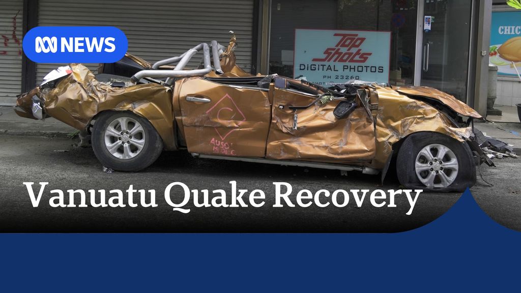 Vanuatu Quake Recovery: A completely crushed car on a street.