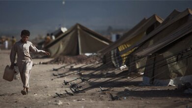 A young boy, internally displaced from the Pakistani's Army's ongoing offensive against the Taliban, walks to collect water a...