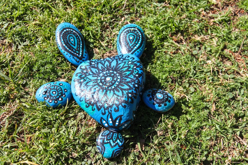 Positioned together, six cleverly painted rocks form a turtle.